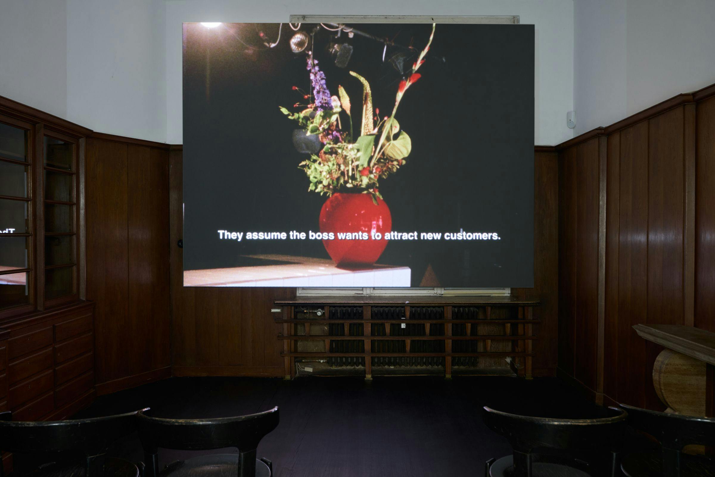 a video projected in a wood panelled room