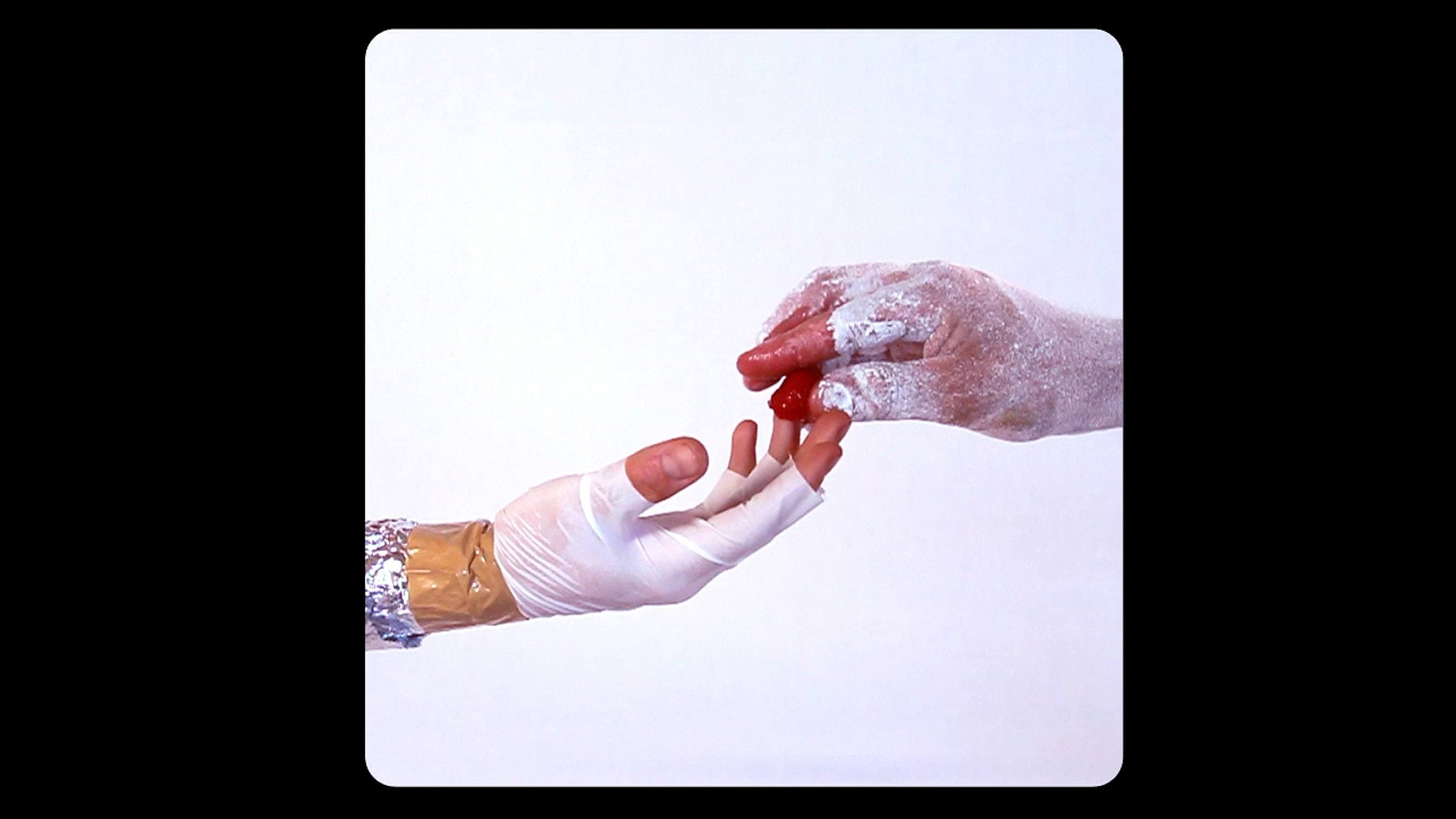 Two hands reach out to each other, covered in plastic and discoloured